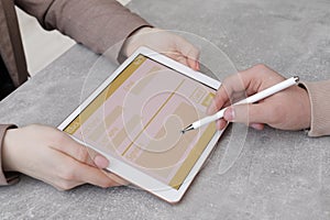 Electronic signature. Man using stylus and tablet at table, closeup