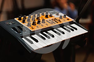 Electronic synthesizer keyboard with control knobs in music studio