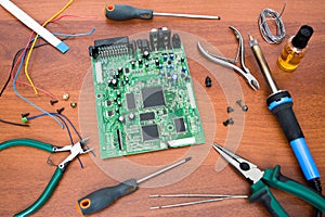 Electronic system board with microcircuits and electronic components. Necessary tools for repair.