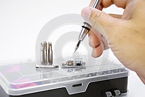 Electronic technician removing metal nut with a multi precision screwdriver