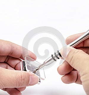 Electronic technician removing metal nut with a precision screwdriver