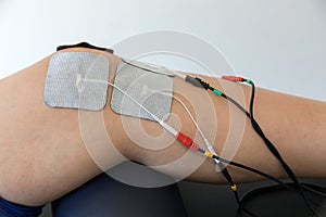 Electronic therapy on knee used to treat pain.