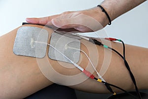 Electronic therapy on knee used to treat pain.