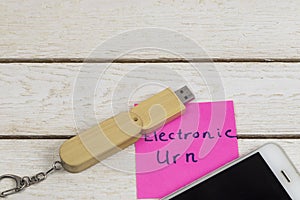 Electronic urn concept: flash drive and cell phone on white background