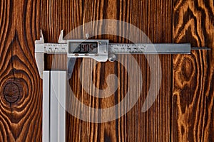 Electronic vernier caliper, wooden background