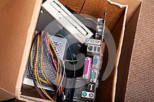 Electronic waste, cardboard box package full of e-waste, old dated desktop pc, computer components. Outdated technology