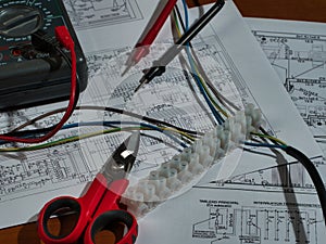 Electronic Work Multimeter Wires Zenith View - Top-down view of a multimeter, terminal block, snips, and wires on complex