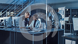 Electronics Development Engineer Working on Computer, Talks with Project Manager. Team of