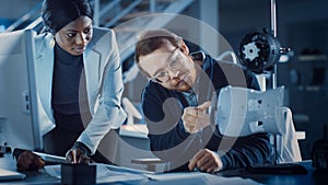 Electronics Development Engineer Working at His Desk, Talks with Project Manager, Shows High Tech