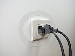 Electronics plugged in to the socket on white wall