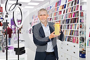 An electronics store seller demonstrates box with mobile phone photo