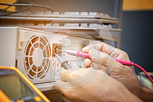 Electronics technician hands use digital multimeter pen checking