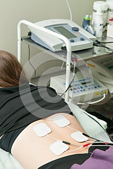 Electrotherapy for a girl in the physiotherapy room photo