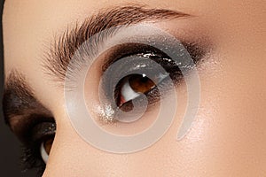 Elegance close-up of female eye with classic dark brown smoky