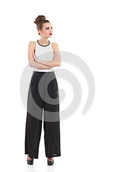 Elegance fashion model is posing with arms crossed.