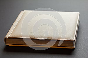 Elegance in Ivory: Handcrafted Faux Leather Wedding Album on Grey Background