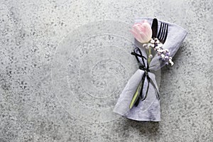 Elegance spring table setting with pink tulip on grey. Easter dinner. Top view