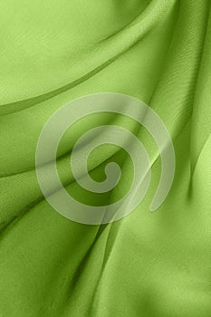 Elegant abstract background with diagonal waves of  green  fabric folds
