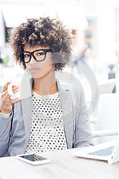 Elegant african american woman drinking coffee, working.