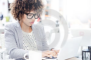 Elegant african american woman working on laptop.