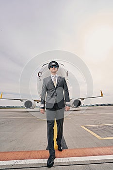 Elegant airline captain walking across the airdrome