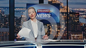 Elegant anchorwoman reporting newscast tv stage near screen. Woman breaking news