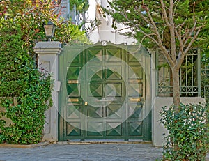 Elegant apartment building entrance green metallic door, Athens Greece