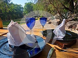 Elegant assembly of plates and glasses with decoration valentine`s day, outdoor breakfast for lovers in glamping photo