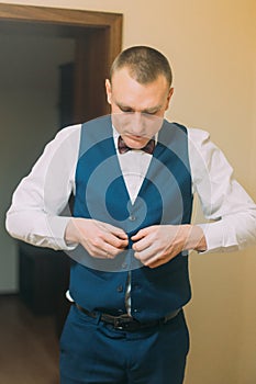 Elegant athletic man dressing blue tuxedo suit for festive event