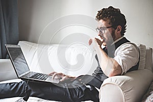 Elegant attractive fashion hipster man using notebook