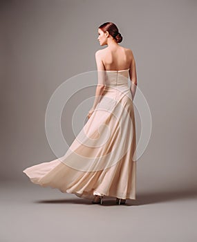 Elegant backless moscato dress. Beautiful pink chiffon evening gown. Studio portrait of young ginger woman. Transformer dress idea