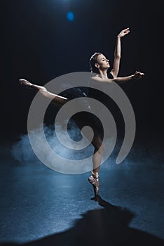elegant ballerina dancing in pointe shoes and black tutu in studio