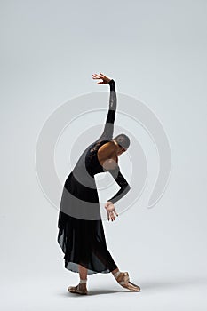 Elegant ballerina. A young graceful ballet dancer, dressed in pointes shoes demonstrates her dance skills. Power and refinement of