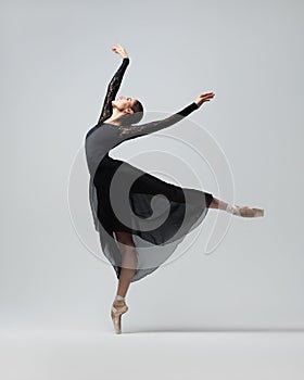 Elegant ballerina. A young graceful ballet dancer, dressed in pointes shoes demonstrates her dance skills. Power and refinement of