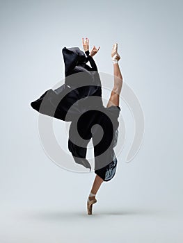 Elegant ballerina. A young graceful ballet dancer, dressed in pointes shoes demonstrates her dance skills. Power and refinement of