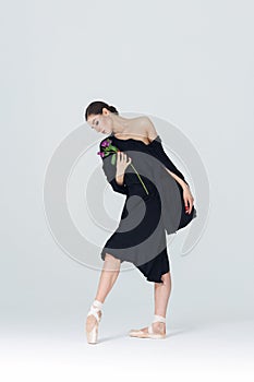 Elegant ballerina. A young graceful ballet dancer, dressed in pointes shoes demonstrates her dance skills. Power and refinement of