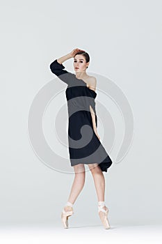 Elegant ballerina. A young graceful ballet dancer, dressed in pointes shoes demonstrates her dance skills. Power and refinement of