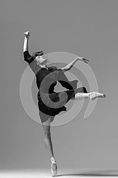 Elegant ballerina. A young graceful ballet dancer, dressed in pointes shoes demonstrates her dance skills. Power and refinement of