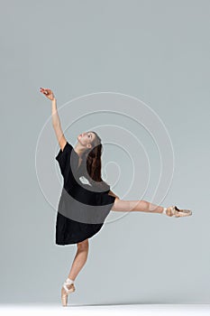 Elegant ballerina. A young graceful ballet dancer, dressed in pointes shoes demonstrates her dance skills. Power and refinement of