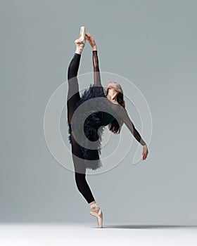 Elegant ballerina. A young graceful ballet dancer, dressed in pointes shoes demonstrates her dance skills. Power and refinement of