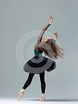 Elegant ballerina. A young graceful ballet dancer, dressed in pointes shoes demonstrates her dance skills. Power and refinement of