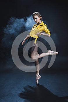 elegant ballet dancer in pointe shoes and black tutu and yellow leather