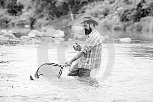 Elegant bearded brutal hipster man fishing. Fishing requires to be mindful and fully present in moment. Successful catch