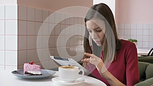 Elegant beautiful caucasian woman using tablet computer, texting, typing. Smiling in cafe 60 fps