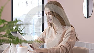 Elegant beautiful caucasian woman using tablet computer, texting, typing. Smiling in cafe 60 fps