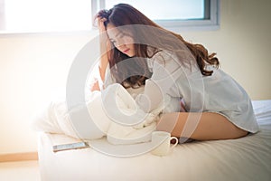 Elegant beautiful woman wearing white shirt posing in bedroom,