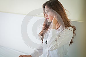 Elegant beautiful woman wearing white shirt posing in bedroom,