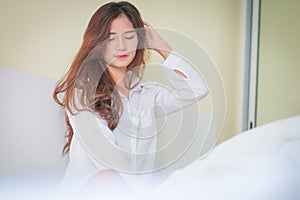 Elegant beautiful woman wearing white shirt posing in bedroom,