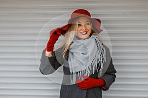 Elegant beautiful young woman in a fashionable hat with a gray