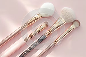 Elegant beauty brushes, white and gold, on gentle pink background